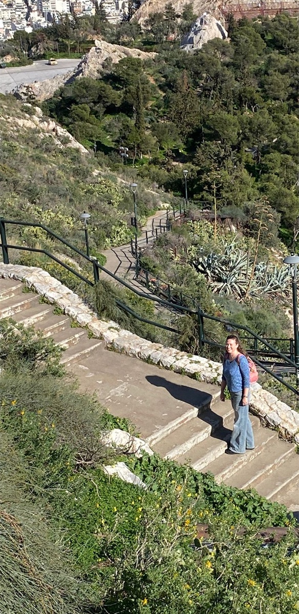 Mor walking down stone stairs on a green hillside